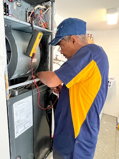 Professional technician installing a ductless mini-split heat pump system